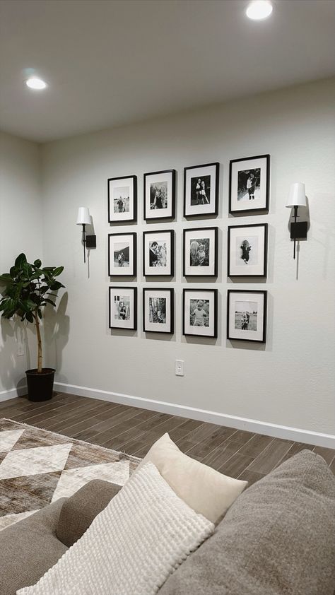 Picture wall, family picture wall, gallery wall, living room decor, neutral home decor, sconces Lounge Room Photo Wall, Small Living Room Picture Wall, Aesthetic Pictures Frame, Home Picture Wall Ideas, Family Pictures Frame, Gallery Wall And Sconces, Family Photo Wall With Lights, Lounge Photo Wall Ideas, Family Pic Collage On Wall