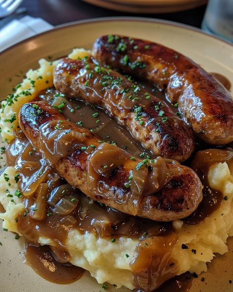 Classic Bangers and Mash with Rich Onion Gravy Ingredients: 8 pork sausages (traditional British bangers) 4 large potatoes, peeled and cut into chunks 4 tablespoons unsalted butter 1/2 cup milk (or more, as needed) Salt and pepper, to taste For the Onion Gravy: 2 large onions, thinly sliced 2 tablespoons unsalted butter 2 tablespoons all-purpose flour 2 cups beef or chicken broth 1 tablespoon Worcestershire sauce Salt and pepper, to taste Instructions: Step 1: Cook t... Mash Potatoes And Gravy, British Food Recipes, British Bangers, Potatoes And Chicken, British Food Traditional, Sausage And Mash, British Foods, Pork Sausages, Gravy Ingredients