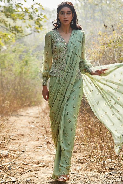 Featuring a mint pre-stitched saree in georgette base with sequins, zari, dabka, cutdana, and moti hand embroidery including lily print. It is paired with a matching jacket and a blouse having balloon sleeves. This contains only three pieces.     FIT: Fitted at bust and waist.  COMPOSITION: Georgette.  CARE: Dry clean only. Luxury Chanderi Pre-draped Saree For Designer Wear, Luxury Anarkali Pre-draped Saree In Pista Green, Luxury Pre-draped Saree With Zari Work In Art Silk, Luxury Raw Silk Pre-draped Saree With Mirror Work, Luxury Pista Green Chanderi Pre-draped Saree, Luxury Traditional Wear Saree With Unstitched Blouse, Luxury Chanderi Pre-draped Saree For Transitional Season, Luxury Art Silk Pre-draped Saree With Zari Work, Luxury Designer Pre-draped Saree With Block Print