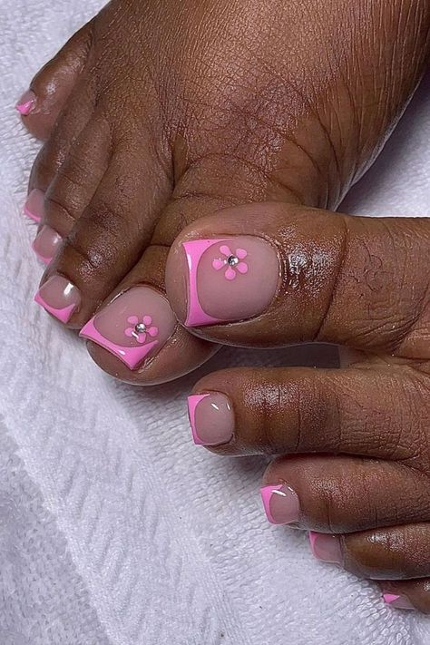 Elevate your pedicure with toe nails donning pretty pink French tips by @humbliztic_nailz, complemented by delicate flower nail art featuring rhinestones for an elegant and feminine touch. Ready to step up your toe nail game? Dive into Nailustrous for 25 Toe Nail Design Ideas and elevate your pedicure style today! Colors For Tan Skin, Summer Pedicure Designs, Toe Nail Colors, French Toe Nails, Flower Toe Nails, Pedicure Designs Summer, Pink Toe Nails, Simple Toe Nails, Feet Nail Design