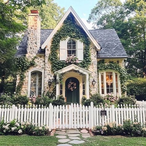 Cottagecore heart is full! 🏡💕 This dreamy abode with its white picket fence, floral accents, and stone chimney is pure magic. Bay windows, cozy porch, and ivy-covered walls create the coziest atmosphere. Pastel colors, vintage details, and a garden path leading to endless possibilities. #cottagecore #dreamhome #countryliving #homegoals #vintagevibes #gardenlife White Picket Fence House Dream Homes, Front Yard Landscaping Victorian Home, Houses With Picket Fences, Cottage With Lots Of Windows, Cottagecore Farmhouse Exterior, Cottagecore Bay Window, Dream Cottage Exterior, Houses With Vines, Vintage House Aesthetic Exterior