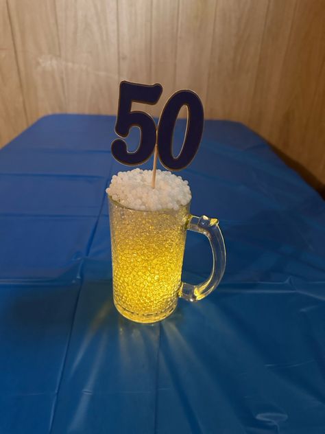 Clear and white orbeez in dollar tree beer mug Beer Stein Centerpiece, Diy Beer Mug, Beer Mug Centerpiece, 50th Birthday Centerpieces, Diy Beer, Beer Theme, Birthday Centerpieces, Adult Birthday Party, Centerpiece Ideas