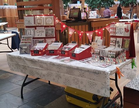 Simple DIY greeting cards craft stall using old cardboard boxes wrapped in red paper & homesewn bunting using fabric scraps. The whole setup cost under £10 Paper Craft Booth Display Ideas, Christmas Craft Stall Display, Christmas Stall Display, Display For Greeting Cards, Craft Show Booth Display Ideas For Greeting Cards, Christmas Craft Stall Display Ideas, Greeting Card Market Display, Christmas Craft Stall Ideas, Christmas Craft Stall