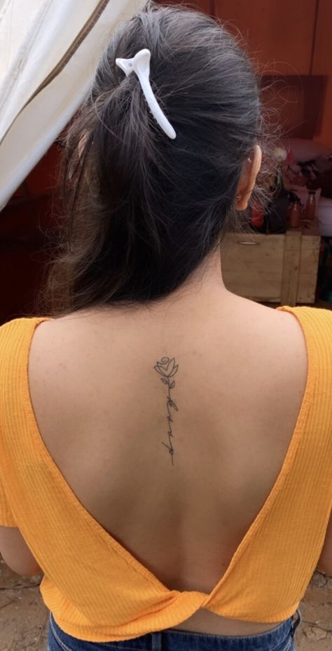 Flower With Initial Stem Tattoo, Back Tattoo Women Simple, Small Flower Spine Tattoo, Back Tattoo Women Rose, Back Tattoo Rose, Hidden Initial Tattoo, Flower Tattoo With Words As Stem, Simple Back Tattoos For Women, Spine Tattoos For Women Dainty