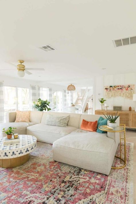 Tan Coach Living Room, Subtle Boho Living Room, Living Room Boho Colorful, Colorful Boho Design, Apartment Decorating Coastal Style, Bright Living Room Rug, Pink Rug In Living Room, Area Rug Aesthetic, Girly Apartments Living Room