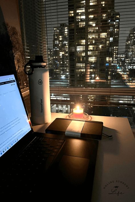 An open laptop on a desk beside a candle and planner with a nighttime cityscape in the background. Study Aesthetic Late Night, Working Late At Night Aesthetic, Night Time Routine Aesthetic Photos, Night Office Aesthetic, Writing At Night Aesthetic, Working At Night Aesthetic, College Night Aesthetic, Night Time Study Aesthetic, Early Adulthood Aesthetic