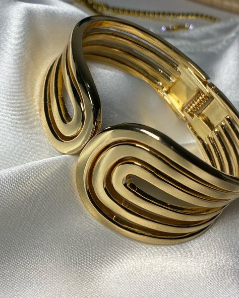 Amelia geometric bangle 🤍🎀 This stylish bangle is designed with a striking gold tone finish, featuring an elegant, geometric pattern of interwoven, curved lines. The design creates a fluid and modern aesthetic, giving the bangle a chic and contemporary look. It is hinged, making it easy to slip on and off, while providing a secure fit, a perfect piece for both casual and formal occasions. Available for N12,000 only. #jewelry #jewelryvendorinlagos #jewelryvendorinibadan #jewelryvendorinikeja #... Geometric Bangle, Jewelry Vendor, Curved Lines, Modern Aesthetic, Formal Occasion, Geometric Pattern, Gold Tones, Bangles, Slip On