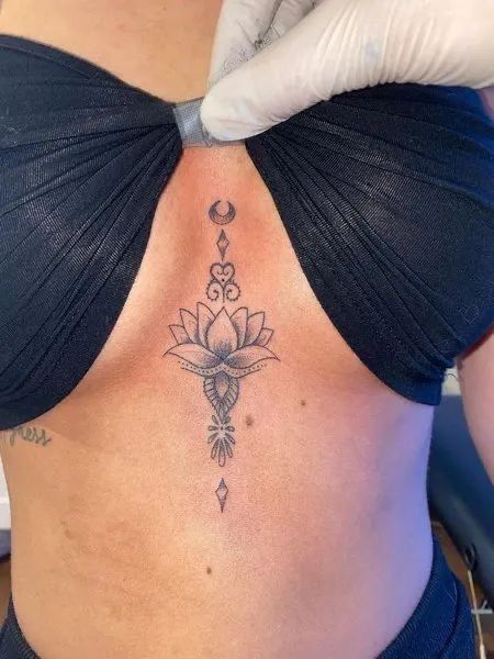 Tattoo Ideas On Sternum, Sternum Tattoos Black Women, Women’s Underboob Tattoo, Lotus Flower Tattoo Under Breast, Underboob Lotus Tattoo, Lotus Flower Tattoo Between Breast, Womens Underboob Tattoo, Flower Between Breast Tattoo, Chest Tattoos Black Women