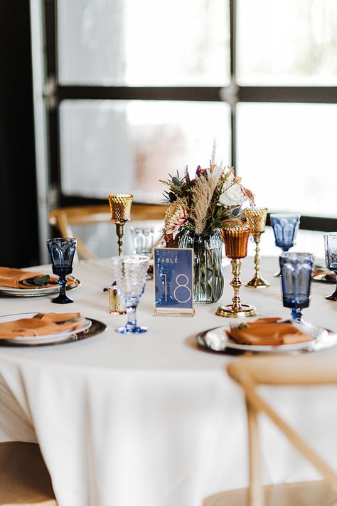 Wedding Reception Tablescape with Unique Blue Debutante Goblet Glassware and Dried Boho Centerpieces |Fall Wedding Design Inspiration Navy Blue And Copper Wedding Table Decor, Navy Terracotta Wedding Table, Navy Fall Wedding Decor, Terracotta And Blue Wedding Palette, Terracotta And Navy Centerpieces, Blue And Orange Wedding Table Settings, Navy Blue Fall Wedding Centerpieces, Navy Rust And Champagne Wedding, Navy Blue And Terracotta Wedding Table