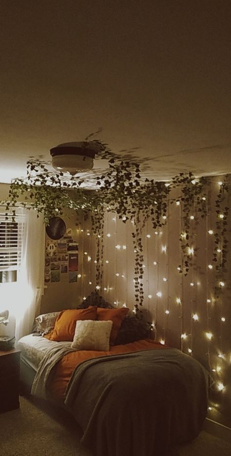 A room with vines hanging from the ceiling Hanging Ivy Bedroom Wall, Vines Led Lights Bedroom, Leafs On Ceiling Aesthetic, Dorm Fairy Lights Room Ideas, Vines In Bedroom High Ceiling, Hanging Veins Bedroom, Curtain Lights Bedroom Wall Vine, Vine Wall Bedroom Ideas, Vines And Flowers On Wall Bedroom