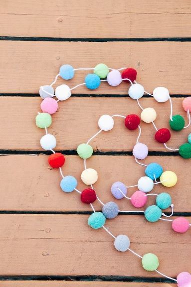 Here's a super easy and inexpensive way to add some colorful and whimsical decor to your kids rooms. Start with some colorful pom poms, a blunt needle and some twine or string. I used cute pink and white baker's twine. Aren't these colors the best?? :) String your thread or twine through the needle. Then simple "sew" through each pom pom. Here's a closeup! These pom poms are not difficult to sew through at all. This project goes very fast, actually! Here's a quick tip… Diy Pom Pom Garland, Pom Pom Necklace, Diy Pom Pom, How To Make A Pom Pom, Pom Garland, Lamb Decorations, Rainbow Room, Pom Pom Garland, Easter Bunny Decorations