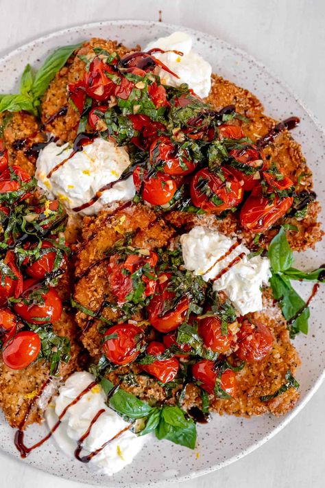 This chicken caprese recipe is packed with flavor and is sure to please everyone at the table! The chicken cutlets are breaded with Italian breadcrumbs and pan-fried until crispy and golden brown. Then, they are topped with garlic-roasted tomatoes, creamy burrata cheese, fresh basil leaves, and a drizzle of balsamic glaze. So easy to make and totally delicious! Chicken Caprese Recipe, Caprese Recipe, Chicken Caprese, Caprese Recipes, Italian Breadcrumbs, 500 Calorie, Burrata Cheese, Caprese Chicken, Chicken Cutlets