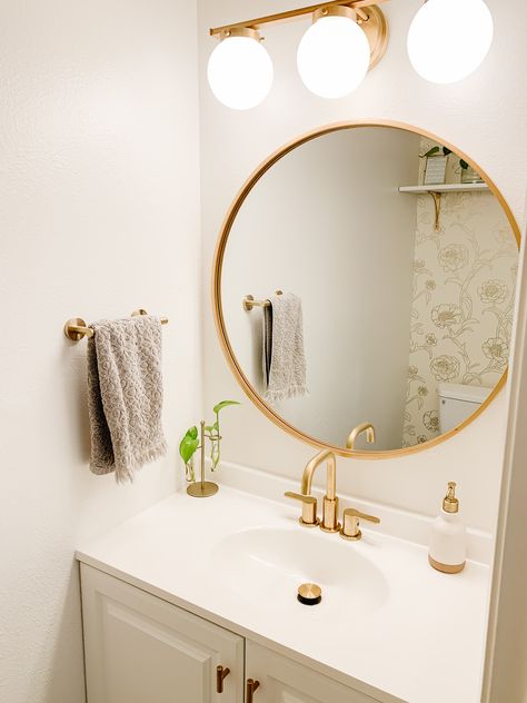 A guest bathroom with white and gold accents and floral wallpaper. Gold Hardware Bathroom, Gold Shower Curtain, Gold Bathroom Decor, White Interior Design, Gold Fixtures, Bathroom Redesign, Bathroom Design Decor, Guest Bathrooms, White Vanity