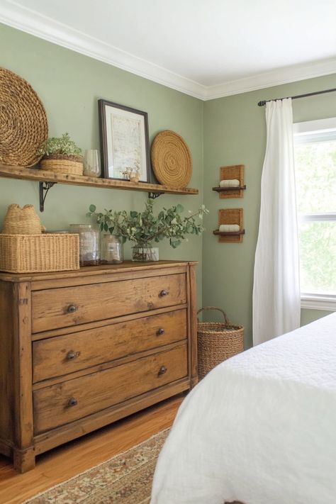 Get the perfect sage green farmhouse look in your bedroom using these quick tips and tricks. California Cool Bedroom Decor, Bedroom Ideas With Small Windows, Sage And Oak Bedroom, Bedroom Cottagecore Aesthetic, Sage Green Room Paint, Brown And Green House Decor, Country Bedroom Color Schemes, Grey Sage Green Bedroom, Forest Green Farmhouse Bedroom