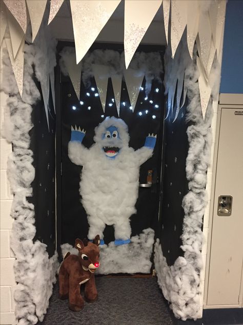 Christmas Door Abominable Snowman - battery powered snow flake lights behind black butcher paper dotted with glue & glitter and lots of snow fluff; Icicles made from poster board and glitter; Snowman made from white, blue, black and red paper covered with lots of snow fluff and a stuffed light up nose Rudolph. Winter Door Decorating Ideas, Kids Door Christmas Decorations, Yeti Decoration Ideas, Rudolph Door Decorations For School, Rudolph Christmas Decor, White Christmas Door Decorations, Blue Christmas Door Decoration, Door Decorations Classroom Winter, Snow Fluff Decor