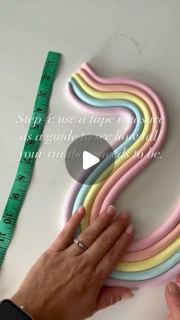 Claire Lawrence Cake Design on Instagram: "A quick video on the making of my wavy rainbows 🌈 
Here a few extra tips for you: 

-For simple shapes like rainbows I prefer to use normal fondant mixed with Tylo powder rather than modelling paste. You do have to be fairly quick with this method though because it can dry out quickly and make it difficult to roll out perfectly. 

- use an acrylic smoother not only to achieve a smooth finish but to also help make sure each colour is the same size. 

- I knew my cake would be approximately 8” tall, but I wanted it to come up towards the top tier so I shaped it to be a bit taller than that. 

- the candy melts help to solidify the rainbow which helps so much with transportation. I also added a couple of splodges of candy melts on the back and attac How To Make Fondant Rainbow, Tall Cakes Birthday, Pastel Rainbow Smash Cake, Rainbow Baby Shower Cake, Fondant Rainbow Cake Topper, Rainbow Smash Cakes, Pastel Rainbow Aesthetic, Rainbow Baking, Fondant Rainbow