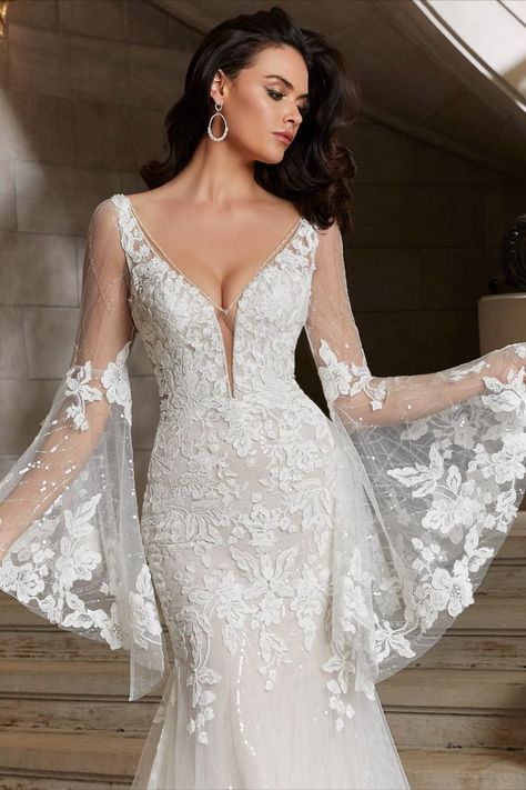 We have fallen in love with this ethereal and breathtaking gown by Morilee. Cassiopeia wedding dress pushes the bridal boundaries with its unique details. The patterned sequin net mermaid features delicate re-embroidered lace appliqués and oversized, detachable bell sleeves adds to the ethereal glow. Wedding Dress With Bell Sleeves, Bell Sleeve Wedding Dress, Crystal Wedding Dress, Madeline Gardner, Elegant Ball Gowns, Dress With Bell Sleeves, Plum Dress, Gown Inspiration, 2022 Wedding