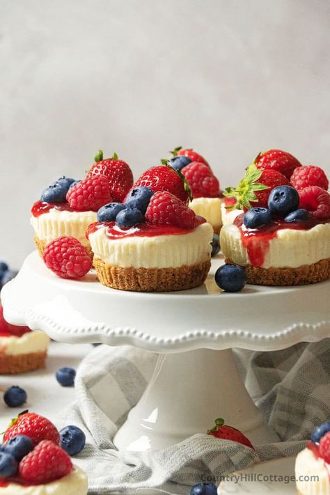 These delicious Philadelphia no bake mini cheesecakes are super simple to make. Smooth, creamy, and with a buttery graham cracker crust, they make a delightful bite-sized dessert that's perfect for any celebration and holiday. Using only a few basic ingredients and minimal equipment, these tiny cheesecakes are formed in a muffin pan and set up in the fridge instead of the oven. Serve them with fruit sauce, berries, whipped cream, caramel, chocolate, and cookies. | CountryHillCottage.com Kraft Mini Cheesecakes, Small Birthday Dessert Ideas, No Bake Mini Fruit Tarts, Small Dessert Cup Ideas, Mini Berry Cheesecakes, Strawberry Cheesecake Bites No Bake, Mini Fruit Cheesecakes, Small Parfait Desserts, Trio Of Desserts Ideas