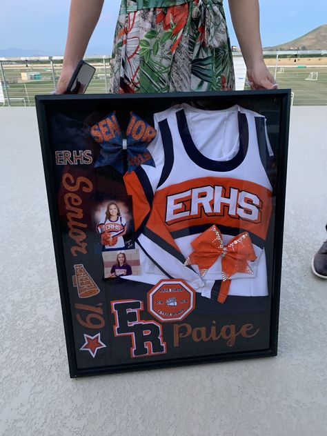 Senior Cheer Ads From Parents, Senior Cheer Boxes Ideas, Framed Cheer Uniform, Senior Cheer Shadow Box Ideas, Cheer Camp Crafts For Kids, Cheer Shout Out Ideas, Cheerleader Shadow Box Ideas, Cheer Wall Ideas, Senior Night Baskets Cheer