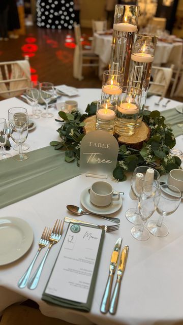 G&L Elegant Occasions on Instagram: "Another lovely night at @bartonhallhotelandspa wedding fair ✨ Sage green and cylinder vases with floating candles is always one table everybody loves! 😍 • • • • • #wedding #weddingday #engaged #engagement #weddingdecor #weddingsnorthamptonshire #weddingseastmidlands #weddingsleicestershire #eventdecor #bridetobe #groomtobe #weddingstyle #venuestyling #venuestylist #wedding2024 #bride2024 #bride2025 #weddingday #venuestyling #venuestylistnorthamptonshire #bartonhall #bartonhallwedding #sagegreen #sagegreenwedding" Wedding Table On A Budget, Green Simple Wedding Decor, Green And Beige Wedding Table Decor, Sage Green White And Gold Centerpieces, Plant Table Setting, Olive Green Wedding Theme Table Settings, Sage Green And Silver Wedding Table Settings, Gold And Sage Wedding Decor, Sage Green And White Wedding Table Settings