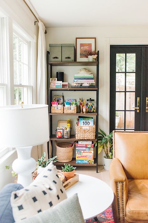 Bookcase With Toy Storage, Bookshelf Family Room, Bookshelf In Playroom, Chair Next To Bookshelf, Bookshelves Next To Window, Living Room Corner Storage, Toys In Living Room Small Spaces, Kid Storage Living Room, Kids Bookshelf Decor