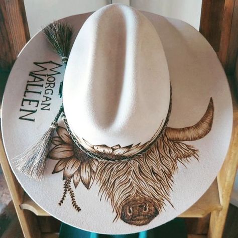 Bespoke Fedora Hat's & Hat Burning ✿ on Instagram: "I think I can hear a stampede...... The highland cow design is becoming a huge hit Here is the original highland cows baby sister off to rock out @morganwallen #customhats #burntdesigns #highlandcow #artist #pyrographyart #design #solspirits #cmcrocks #aussiebusiness #smalbiz #akubra #feltburning" Cow Print Burned Hat, Custom Burned Hat Ideas, How To Burn A Hat, Burned Hat Design Ideas, Stencils For Hat Burning, Burnt Hat Design, Felt Hat Burning Designs, Highland Cows Baby, Hat Burning Designs