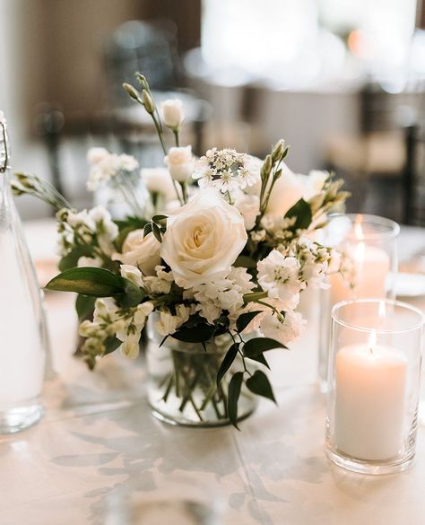 Sweet and petite wedding centerpiece

Vase centerpiece with white roses, white lisianthus, white larkspur, ruscus greens, votive candles
⁠ Wedding Centerpieces Low Flowers, White Centerpiece Wedding Simple, Simple Wedding Table Centerpieces Votive Candles, Simple White Centerpieces Flower, Small Table Centrepiece, Bud Flowers Wedding Table, Minimal Flower Centerpieces, Simple Rose Centerpiece Wedding, White Rose Centrepiece