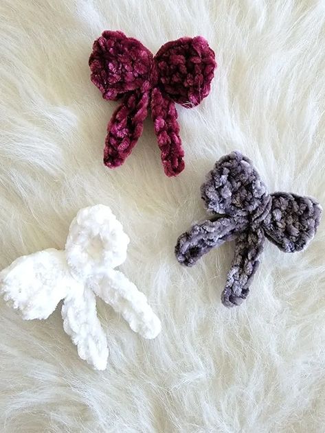 This versatile crochet bow pattern comes in 2 sizes, making it perfect for both children and adults. You can add a clip or an elastic tie to it. Crochet Bow Tie For Teddy Bear, What To Crochet With Velvet Yarn, Crochet Mini Bow, Crochet Christmas Hair Clips, Velvet Yarn Crochet Ideas, Velvet Yarn Patterns, Crochet Velvet Yarn Patterns, Crochet Velvet Yarn, Bow Crochet Pattern