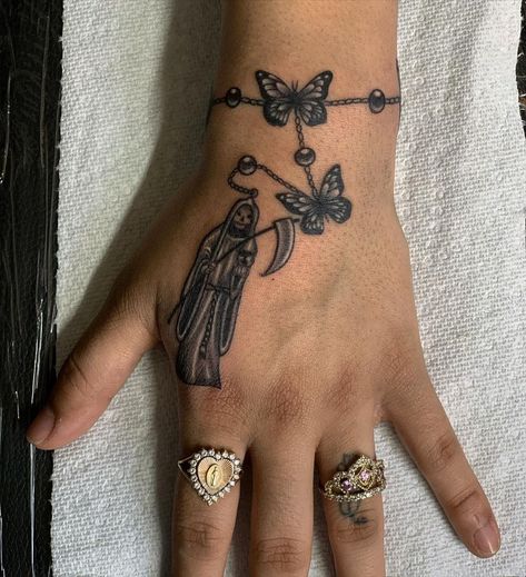 31 Santa Muerte Tattoos: The Meaning Behind This Powerful Design - Body Artifact Santa Muerte Hand Tattoo, Michoacan Tattoo Ideas, Small Santa Muerte Tattoo, Santa Muerte Tattoo Pequeño, San La Muerte Tattoo, La Santa Muerte Drawing, Santa Muerte Nails, Santa Muerte Tattoo For Women, Santa Muerte Drawing Tattoo