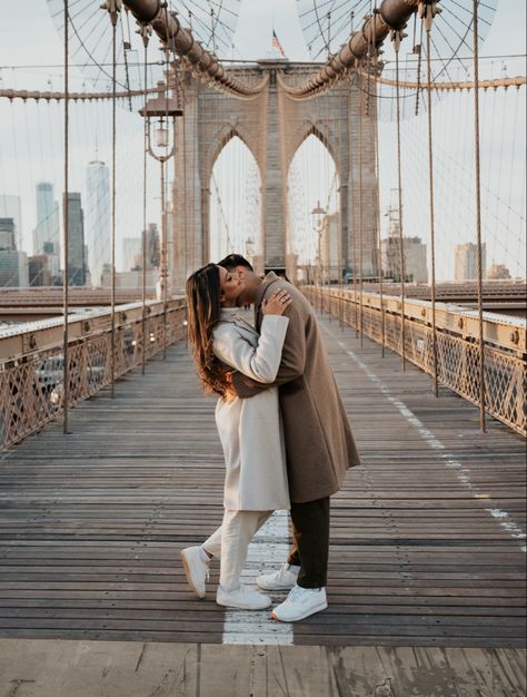 Man kissing woman on the cheek for their engagement photos taken in brooklyn at the brooklyn bridge in new york city New York Couple Outfit, New York Couple Photography, Brooklyn Bridge Picture Ideas Couple, New York Winter Engagement Photos, Brooklyn Bridge Couple Photoshoot, Nyc Winter Couple Photos, Brooklyn Couple Photoshoot, Brooklyn Bridge Couple Pictures, Pictures In New York Ideas