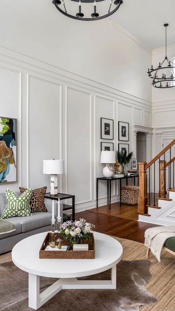 Erika Ward Interiors on Instagram: "Tall ceilings can be intimidating if you’ve got a big blank wall staring you in the face. We transformed this room with stunning trim moldings! 🌟 These timeless details elevate any room, adding classic elegance and boosting your home’s resale value. Invest in style that lasts! 🏡✨ #HomeDecor #TimelessDesign #TrimMoldings #HomeImprovement #ErikaWardInteriors" Wall Molding Cathedral Ceiling, Wainscoting Ideas Living Room High Ceiling, Tall Wall Moulding Ideas, Wall Molding On Angled Wall, High Ceiling Wall Paneling, Wall Paneling With Vaulted Ceiling, High Ceiling Entry Way Wall Decor, Wall Paneling Tall Ceiling, Wall Molding Tall Ceilings