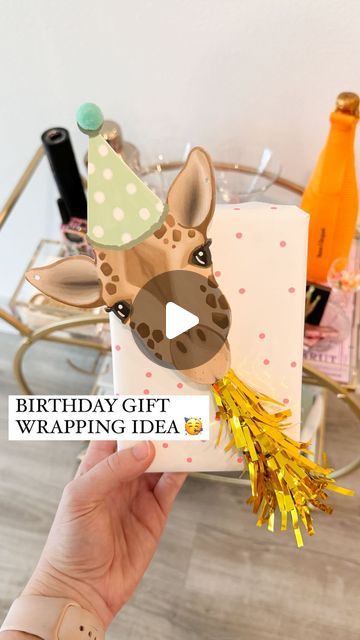 Shelby | Gift-in-a-Box Guide on Instagram: "YOU’RE NOT READY FOR HOW CUTE! 🥳🎁🦒  Comment ZHUZH for the animal garland & everything else I used to wrap this gift!   This is a new way to use the cute party horns for gift wrapping! Just grab a cute animal garland / cutout and add the blower using hot glue or foam tape to secure it   The garland came with 20 die cut animals and the party horns come in a pack of 6 so you can easily rinse and repeat this same method for a bunch of gifts!   I also ended up adding some letter beads to the top right corner for the name which made it even cuter  An easy way to create a Pinterest-esque gift! ✨  What should we name him?!?  #birthday #birthdaygifts #bdaygift #birthdaygiftideas #giftwrappingideas #giftwrapping #giftwrappinginspiration #giftwrappingins Animal Wrapping Ideas, Over The Top Gift Wrapping, Fun Ways To Wrap Birthday Gifts, Unicorn Gift Wrapping Ideas, Stuffed Animal Gift Wrapping Ideas, First Birthday Wrapping Ideas, Fun Gift Wrapping Ideas Birthdays, Fun Birthday Wrapping Ideas, Animal Gift Wrapping Ideas