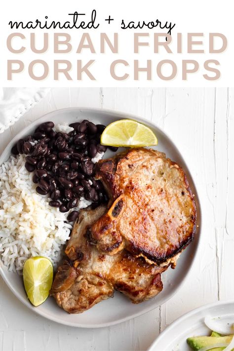 A white plate with chuletas de puerco on it beside white rice and black beans with the words "marinated and savory cuban fried pork chops" in the foreground Cuban Sauce For Pork, Cuban Pork Chops Recipes, Creole Pork Chops, Cuban Style Pork Chops, Caribbean Pork Chops, Sides For Fried Pork Chops, Cuban Pork Crockpot, Mexican Pork Chop Recipes, Mojo Pork Chops