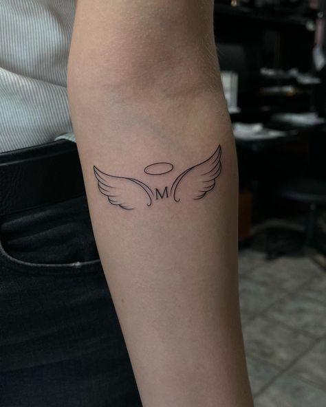 Best 70+ Wing Tattoo Designs Ideas - May 2024 Forearm Tattoo Women Angel Wings, M With Angel Wings Tattoo, Wings With Letter Tattoo, Letter With Angel Wings Tattoo, Letter M Tattoo Designs, Tattoo Below Elbow, Letter M Tattoo Ideas, M Letter Tattoo, Angel Wing Tattoo On Arm