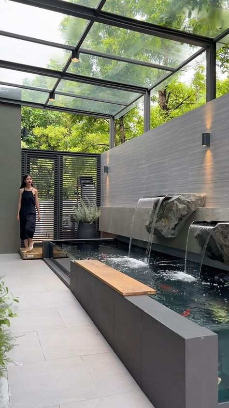 There is a koi pond on the side of the house, with a clear glass wall that allows for a side view of the fish. Adjacent to the pond is a… | Instagram Outdoor Fish Ponds, Fish Ponds Backyard, Terrace House Exterior, Koi Pond Design, Fish Pool, Outdoor Wall Fountains, Kolam Koi, Fish Pond Gardens, Garden Pond Design