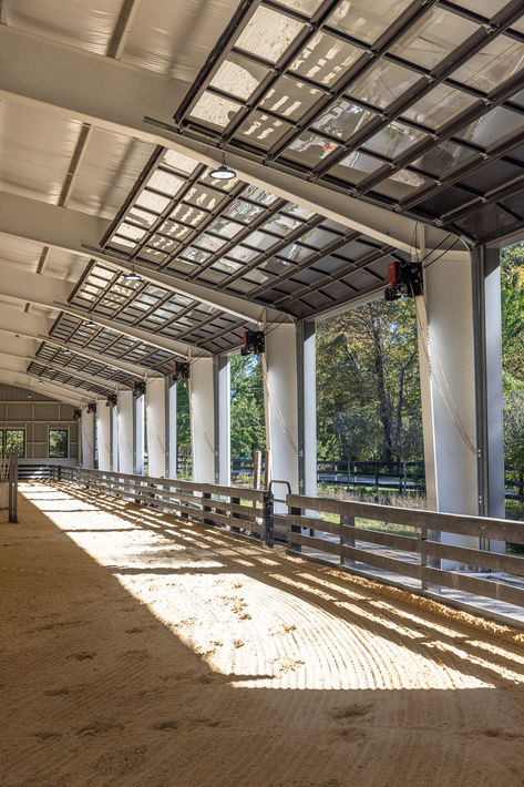 If you can't decide whether to build an indoor or outdoor riding arena, don't! Get the best of both worlds. Fully enclosed when all of its doors and windows are shut, this arena has oversized “garage doors” that can be opened up to let in the fresh air. Stable Doors Horse, French Horse Stables, Indoor Arena Ideas, Covered Arena Ideas, Horse Stables Aesthetic, Horse Arena Wedding, Indoor Riding Arena With Stalls, Barn With Indoor Arena, Indoor Arena Horse