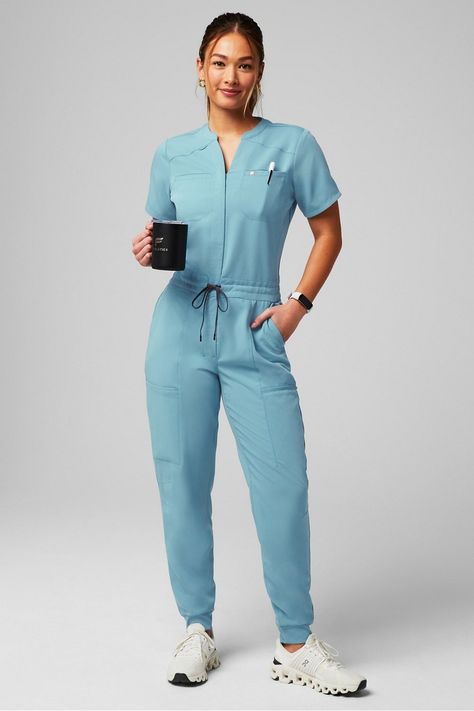 Empower Scrub Jumpsuit - Yitty Dentist Scrubs Woman, Professional Scrub Outfit, Female Doctor Photoshoot, Peds Nurse Outfit, Nurse Style Scrubs Fashion, Scrubs Jumpsuit, Scrubs Uniform Aesthetic, Nursing Outfits Scrubs, Scrub Outfit Ideas