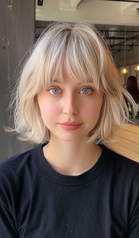 Platinum blonde bob with wispy bangs is effortlessly chic, modern. The light blonde shade adds a striking contrast, making blue or green Shaggy Blonde Bob With Bangs, Platinum Blonde French Bob, Blond Short Hair With Bangs, Short Blonde With Bangs, Winter Bob Hair, Short Bob With Wispy Bangs, Wispy Fringe Short Hair, Platinum Bob Hair, Platinum Blonde Bob With Bangs