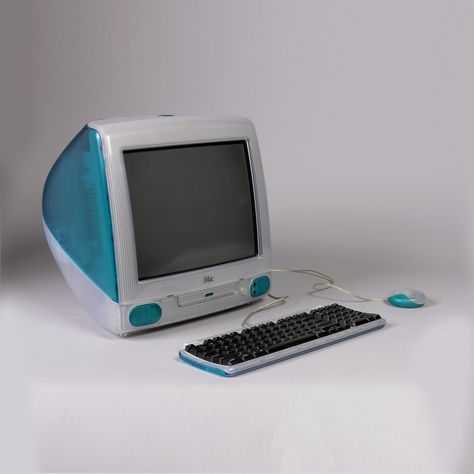 Egg-shaped computer/monitor unit (a) of translucent clear and blue plastic, with screen, CD drawer and two small speakers at front; carry handle inset in top rear; retractable blue foot bar on underside at front.  Two accompanying components are also of translucent clear and blue plastic: one, a flat rectangular keyboard (b) with black keys, retractable foot bar and cord; the other, a circular mouse with cord (c). Imac G3, Alter Computer, Imac Desk Setup, Apple Computers, Apple Macintosh, Shingle Colors, Old Tech, Old Computer, The Oregon Trail