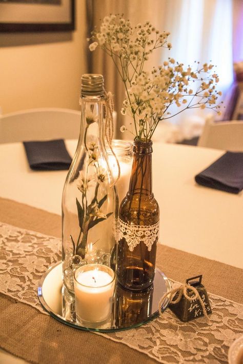 Wine bottle vases sitting atop of a round mirror with votive candle rests on a burlap & lace table runner, complete with a bell to "ring for a kiss." Wine Centerpieces, Wine Decorations, 39 Birthday, Spring Soiree, Wine Bottle Vases, Wine Bottle Centerpieces, Wedding Wine Bottles, Table Runner Diy, Bottle Centerpieces