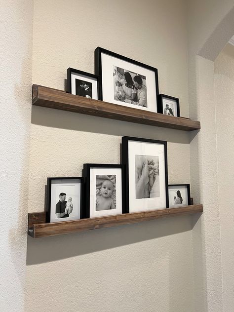 Black and white photos on floating shelf. Ikea picture frames Ikea Photo Shelf, Photo Shelf Decor, Picture Frames On Shelf, Floating Shelf Above Couch, Ikea Picture Frames, Shelf Above Couch, Ikea Picture Frame, Shelf Ikea, Bathroom Picture Frames