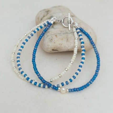 "This triple layer Cornish Blue Bracelet has been lovingly made using mixed patterns of Glass Seed Beads and detailed with a Freshwater Pearl. If the size you require is not showing, just send me a message and I will make one up for you. Threaded on strong 7 strand Tiger Tail wire and finished with wire guardians, and a toggle clasp. More Colours and Designs can be found at: https://www.etsy.com/uk/shop/CraftHutCornwall?section_id=31245004 Typical packaging as shown in images. I have carefully s Beach Seed Bead Bracelets, Cute Blue Beaded Bracelets, Fun Handmade Blue Beaded Bracelets, Fun Blue Beaded Bracelets, Cute Handmade Blue Beaded Bracelets, Cute Colorful Beaded Blue Jewelry, Sea Bead Bracelets, Blue Bracelet Beads, Blue Seed Bead Bracelet