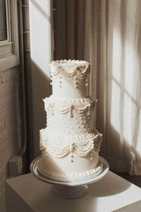 A white three tiered wedding cake with vintage swap piping and polka dots Bespoke Wedding Cake, Wedding Cake Tiers Sizes, Wedding Cake Aesthetic Simple, Wedding Cake White Piping, Classic Cake Piping, Vintage Wedding Cake Just Married, Vintage Theme Wedding Cake, Wedding Tres Leches Cake, White Tiered Wedding Cake