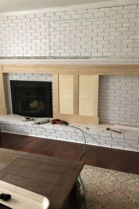 In this tutorial, you'll learn how to build a DIY fireplace mantel with built in bookcases. Step 1: Do a Mockup with TapeAs you can see in this image, we used masking tape to a mock up of where the mantel and built ins would go before we started the project!Step 2: Gather MaterialsFor this project, we used: (3) 4×8 sheets (1/2 inch) of Ecuadorian Plywood – (used for the majority of the project, for the mantel including the mantel posts and as backboard to connect the bookcases & man… Off Center Fireplaces, Extra Wide Fireplace Mantle, Brick Fireplace With Brick Mantle, Built In Brick Fireplace, Brick Wall With Fireplace Makeover, Off Center Mantle, Old Fireplace Remodel, Fireplace Wall Remodel, Whole Brick Wall Fireplace Makeover