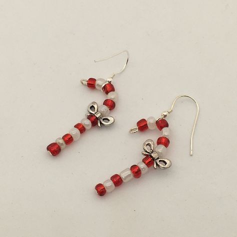 Fun Christmas earrings, beaded candy cane design dangle earrings.  Created with red and white glass seed beads and featuring a a pewter bow.  The canes hang from a sterling silver ear wire.  A great idea for Christmas stocking fillers. The cute earrings drop 4cm in length. They are available to be shipped immediately and will arrive packaged in a kraft paper pillow box ready to give as a gift or as a gift for yourself! Diy Christmas Earrings Beads, Candy Cane Beaded Earrings, Christmas Earrings Beads, Christmas Jewelry Aesthetic, Christmas Seed Bead Jewelry, Earings Beads Ideas, Beaded Earrings Christmas, Christmas Diy Earrings, Cute Christmas Earrings