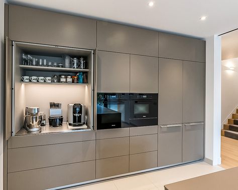 The tall bank of units has been specified and produced to fit perfectly across the wall space, from edge to edge. A shadow gap above is a nice design touch and ensures airflow around the appliances, allowing them to function correctly. A bulthaup b3 pocket door provides a useful space for small appliances and refreshment making items away from the main kitchen area. Above the main cupboard space, top box units take the cabinetry towards the ceiling, giving a wall-like appearance. Kitchen Tall Units, Kitchen Unit Designs, Bulthaup Kitchen, Kitchen Wall Units, Tall Kitchen Cabinets, Kitchen Appliance Storage, Kabinet Dapur, House Design Kitchen, Hus Inspiration