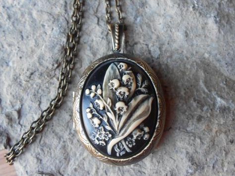 Beautiful cameo locket!!!  The cameo is a gorgeous lily of the valley. Stunning colors, each cameo is individually hand painted and antiqued, each an original!!!  The bronze ans silver plated lockets are victorian style with beautiful scroll on both the front and back about 2" long.  They can hold two photos or a treasured keepsake.  Pass down from generation to generation!!!  The bronze locket includes a 24" adjustable rolo link chain with a lobster claw clasp, and the silver includes a 22" .92 Etiquette Vintage, Funky Jewelry, April 26, Coin Jewelry, Jewelry Inspo, Dream Jewelry, Locket Necklace, Pretty Jewellery, Lily Of The Valley