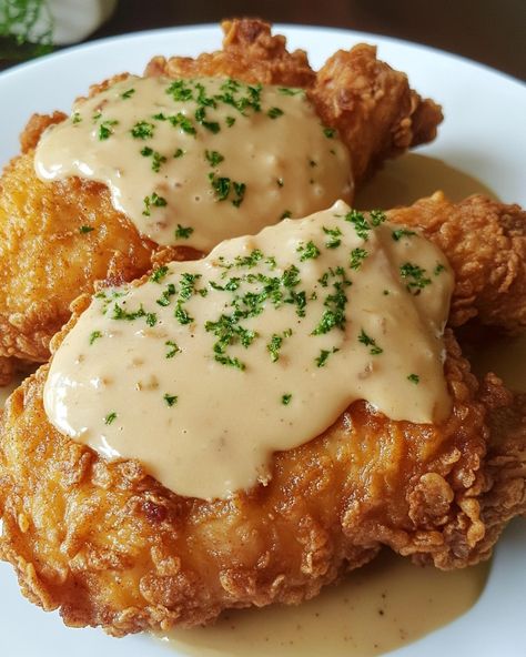 Pan Fried Chicken with Cream Gravy 🍗🍛 Ingredients: - 4 boneless, skinless chicken breasts - 1 cup all-purpose flour - 1 teaspoon paprika - 1/2 teaspoon garlic powder - Salt and pepper, to taste - 1/4 cup vegetable oil - 2 tablespoons unsalted butter - 1 cup whole milk - 1/2 cup chicken broth Instructions: 1. In a shallow bowl, mix flour, paprika, garlic powder, salt, and pepper. Dredge the chicken breasts in the flour mixture, coating well. 2. Heat vegetable oil in a large skillet over me... Garlic Fried Chicken, Chicken Fried Chicken, Cream Gravy, Gravy Ingredients, Pan Fried Chicken, Fried Chicken Breast, Shallow Bowl, Yummy Comfort Food, Nyc Food