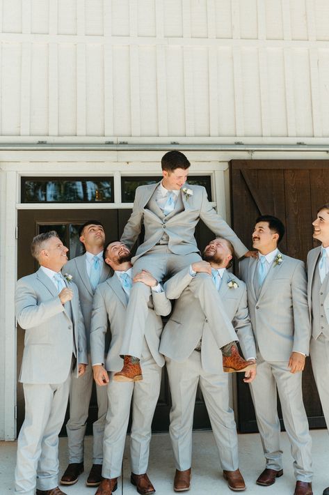 The bridal party complemented the elegant white barn wedding theme and cream, ivory & blue wedding color palette. Bridesmaids wore powder blue dresses with the groomsmen in light grey suits, pale blue ties and brown shoes. See all the magical moments from this rustic, farmhouse style wedding. Check out these groomsmen photo ideas. Captured by Infinite Film + Photo, Atlanta Wedding Photographer. Blue Gray Groomsmen Suits, Blue Wedding Theme Suits, Smoky Blue Wedding Theme, Grey Suits With Blue Ties, Groomsmen Attire With Dusty Blue Bridesmaids, Black Tux With Dusty Blue, Sky Blue Bridesmaids And Groomsmen, Dusty Blue Gray Wedding, Wedding Suits Light Blue