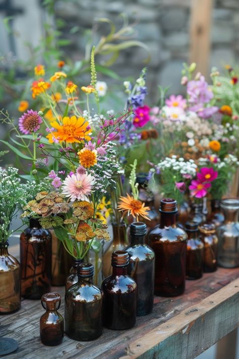 Elevate your wedding decor with a unique touch of the past. These vintage perfume bottles turned vases are filled with an array of herbs and wildflowers, perfect for a bohemian-themed celebration. 🌿🌼💐 A touch of nostalgia meets natural beauty for your special day. #WeddingInspiration #BohoWedding #CenterpieceIdeas #VintageDecor #FloralDesign #DIYWedding #EventStyling #WeddingFlowers Wild Flower Wedding Theme Table Decor, Rustic Whimsical Wedding Decor, Wildflower Reception Decor, Vintage Wildflower Wedding, Thrift Wedding Decor, Wildflower Wedding Reception, Wildflower Theme Wedding, Wildflower Wedding Table Decor, Vintage Wedding Decor